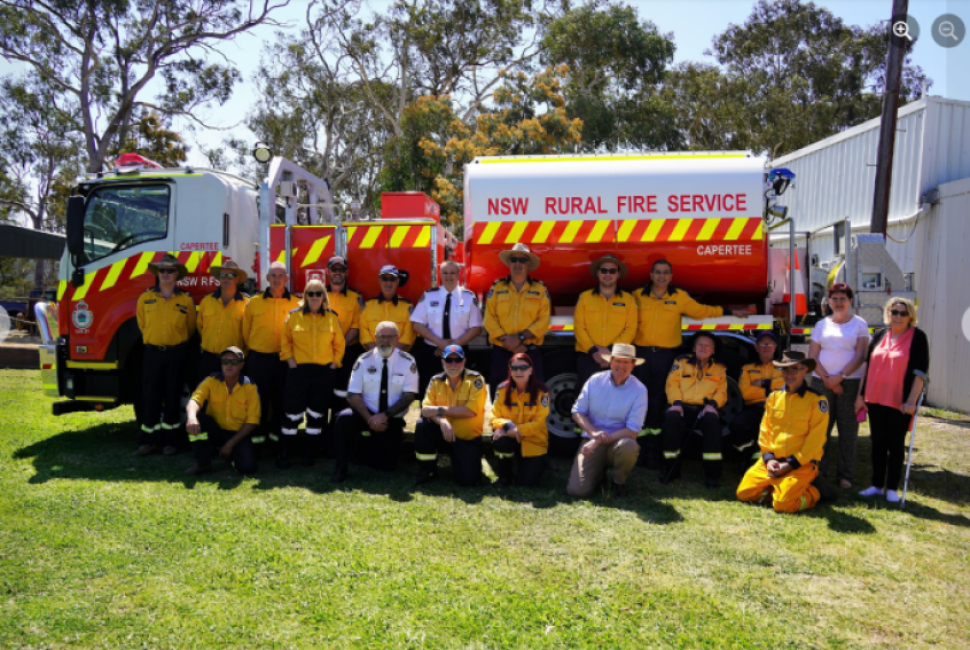 Handover of Capertee Progress Cat 6 RFS bulk water carrier to Capertee and district RFS members who are standing in front of the carrier on the crown lands reserve that is used by both the Capertee and District Progress association and the Capertee RFS.,